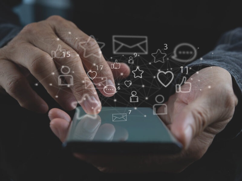 Social media concept. Young business man using mobile smart phone, connecting wifi with social network connection icons on virtual screen, modern people lifestyle